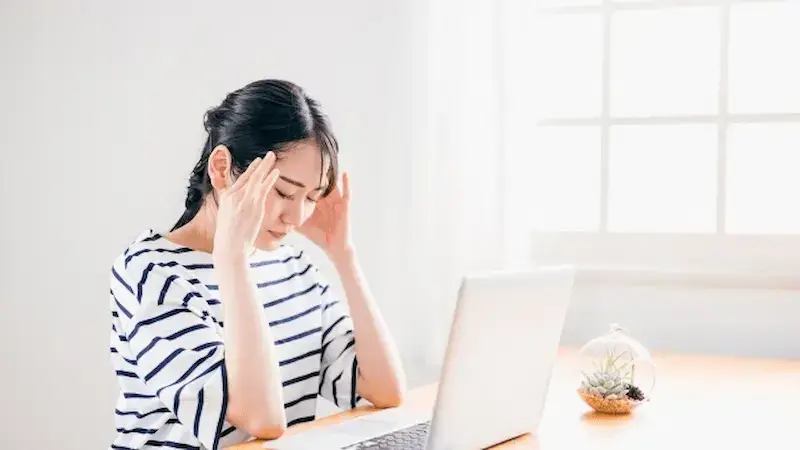パソコンの前で頭を抱える女性